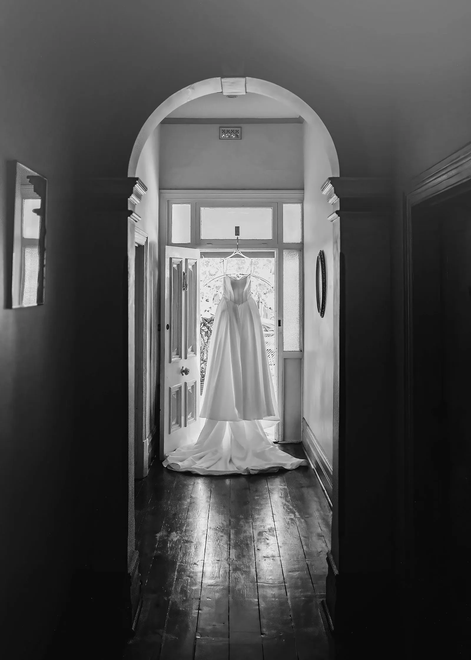 sunnybrae rose garden wedding - celina & anuj 4 Black and white photo of a wedding dress in a hallway.