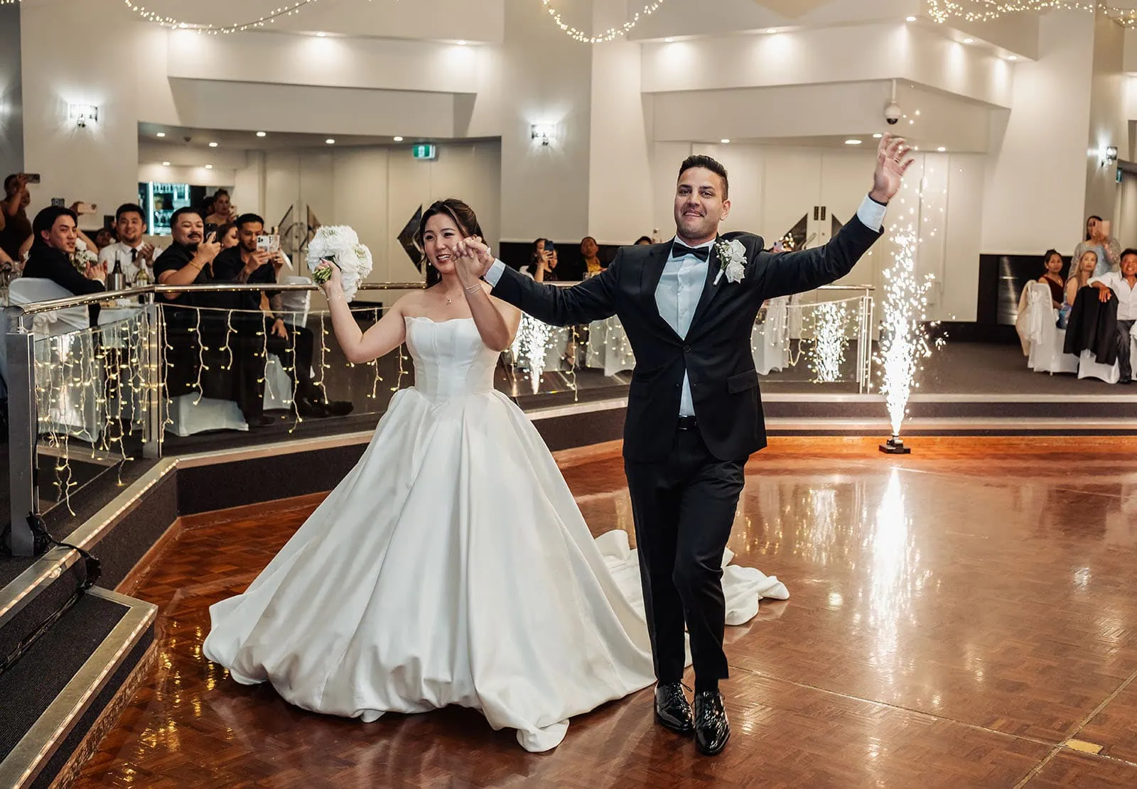 sunnybrae rose garden wedding - celina & anuj 75 Bride and groom joyfully enter wedding venue, guests clap and celebrate their union.