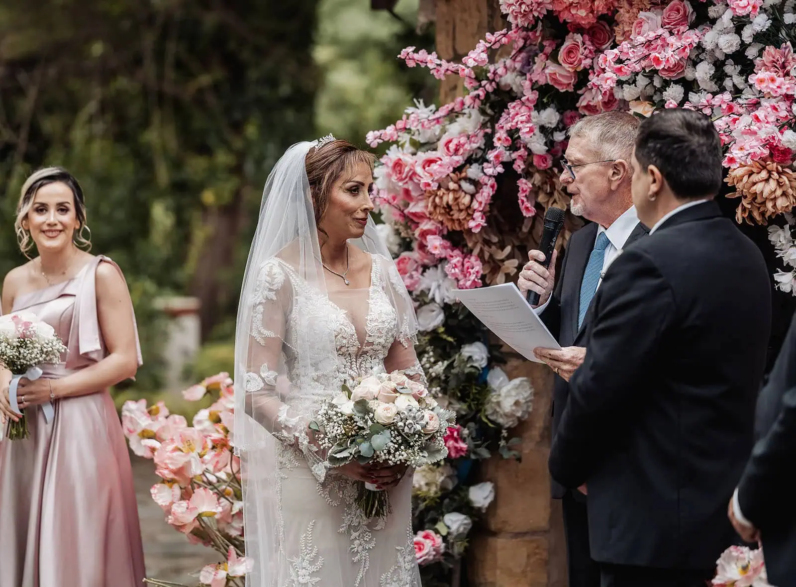 wedding at the manor in basket range - maryam & jason 135 Bride and bridesmaid in floral garden setting at elegant outdoor wedding.