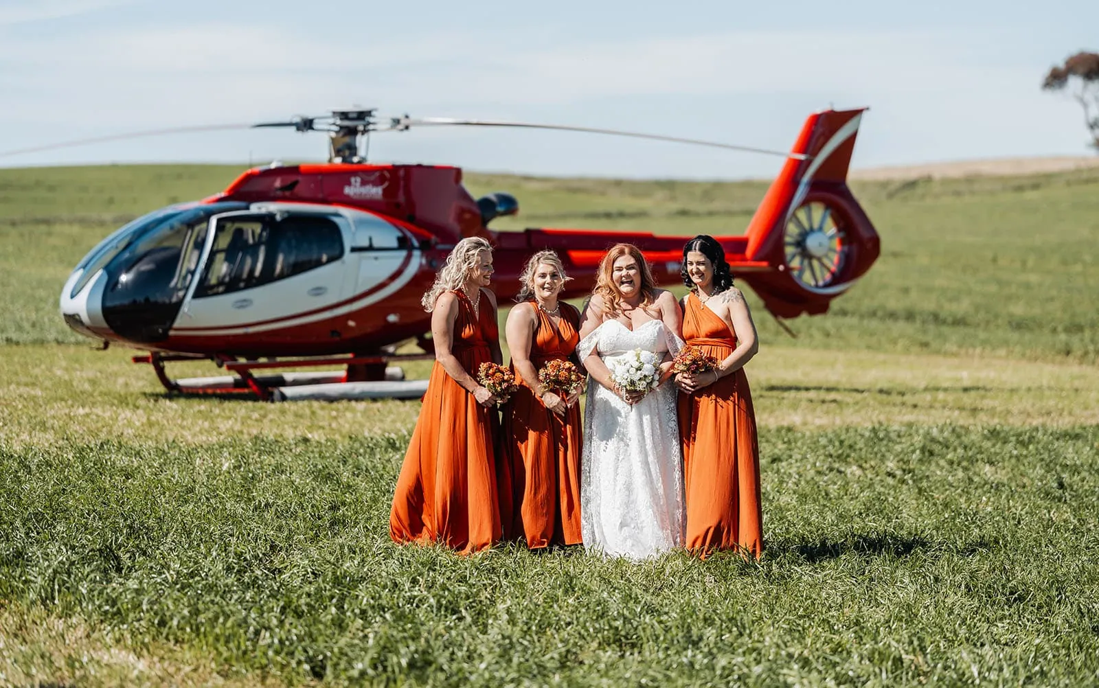 country victoria wedding in corrunnun – rachelle & anthony 330 Bride and bridesmaids with helicopter in field, wedding celebration.