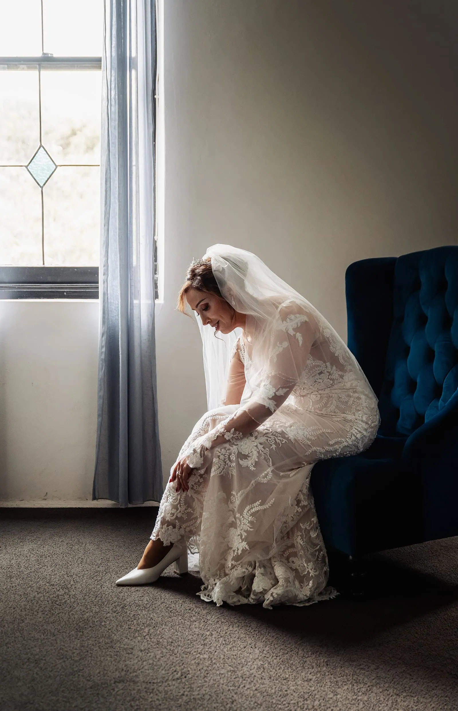 wedding at the manor in basket range - maryam & jason 124 Bride sitting in chair, reflecting before wedding ceremony in elegant dress.