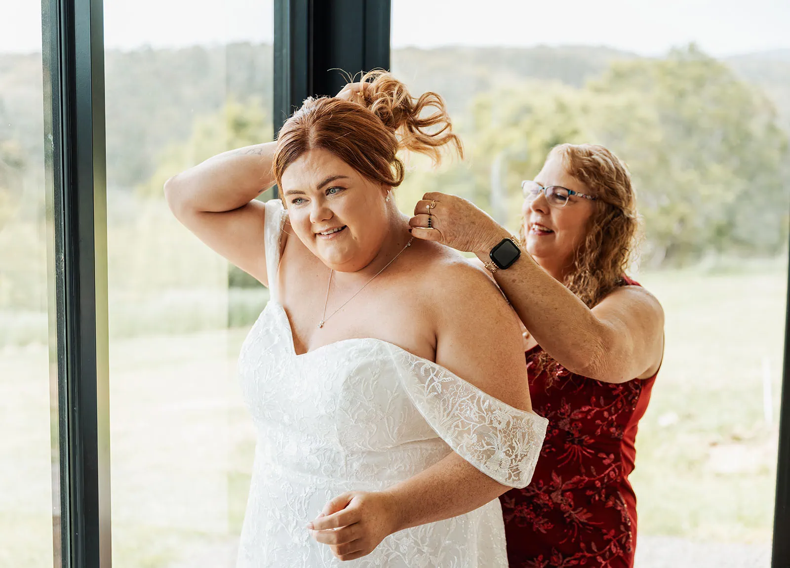 country victoria wedding in corrunnun – rachelle & anthony 306 Bride getting ready in elegant wedding gown, surrounded by floral decor.