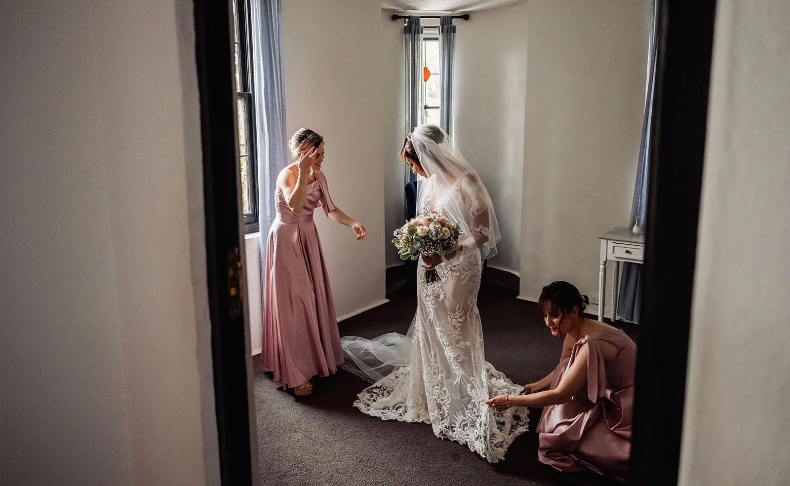 wedding at the manor in basket range - maryam & jason 129 Bride celebrating with bridesmaids in elegant dresses, joyful wedding moment captured.