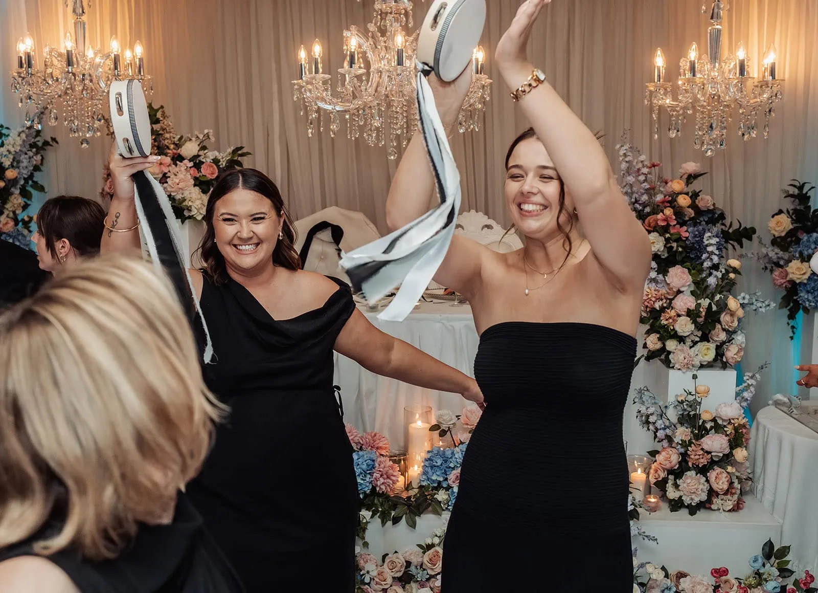 silvestris of clarendon wedding - sam & wayne 272 Women enjoying a party under elegant chandeliers.