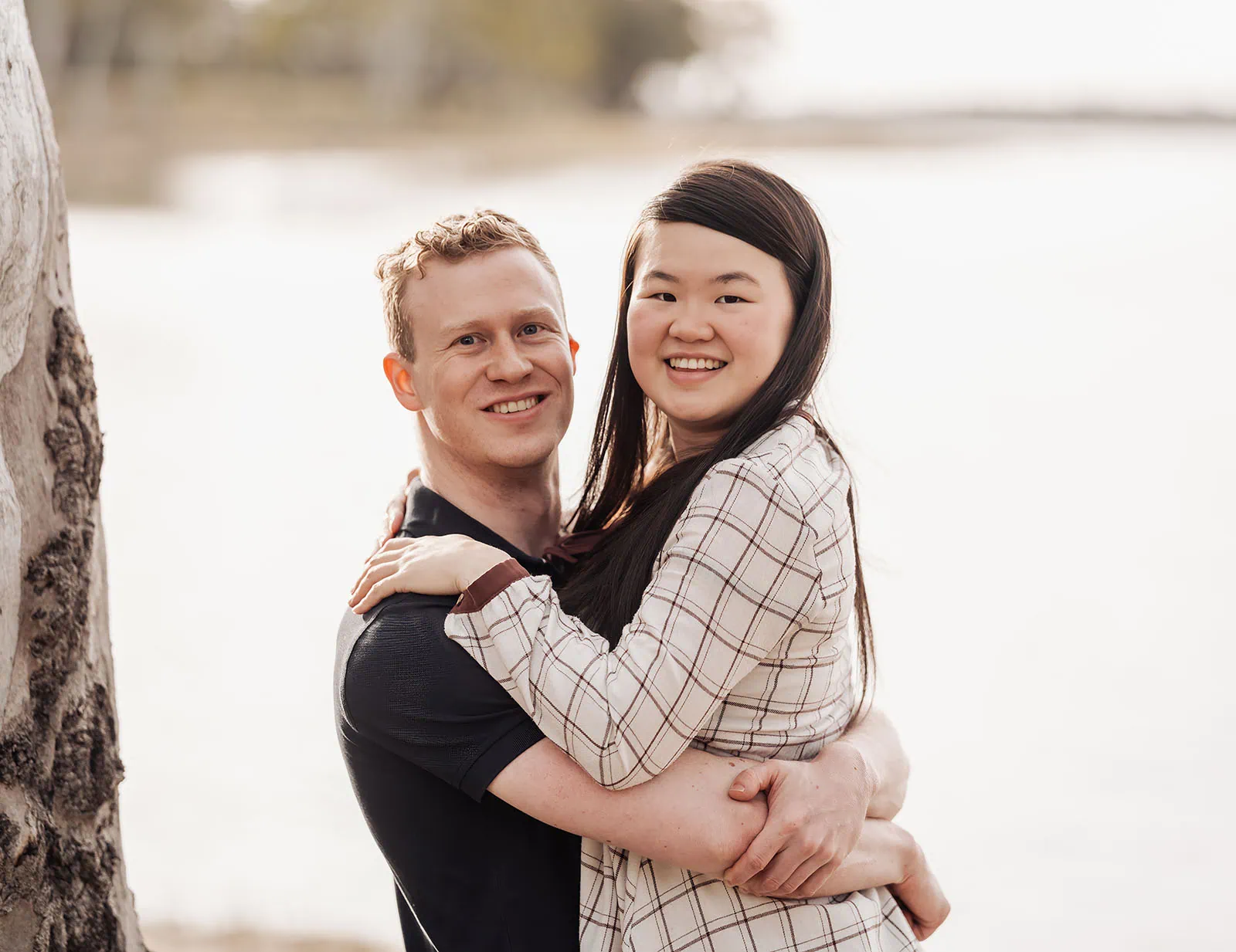 happy valley reservoir family shoot 96 Couple embracing by serene lake, showcasing love and tranquility in natural setting.