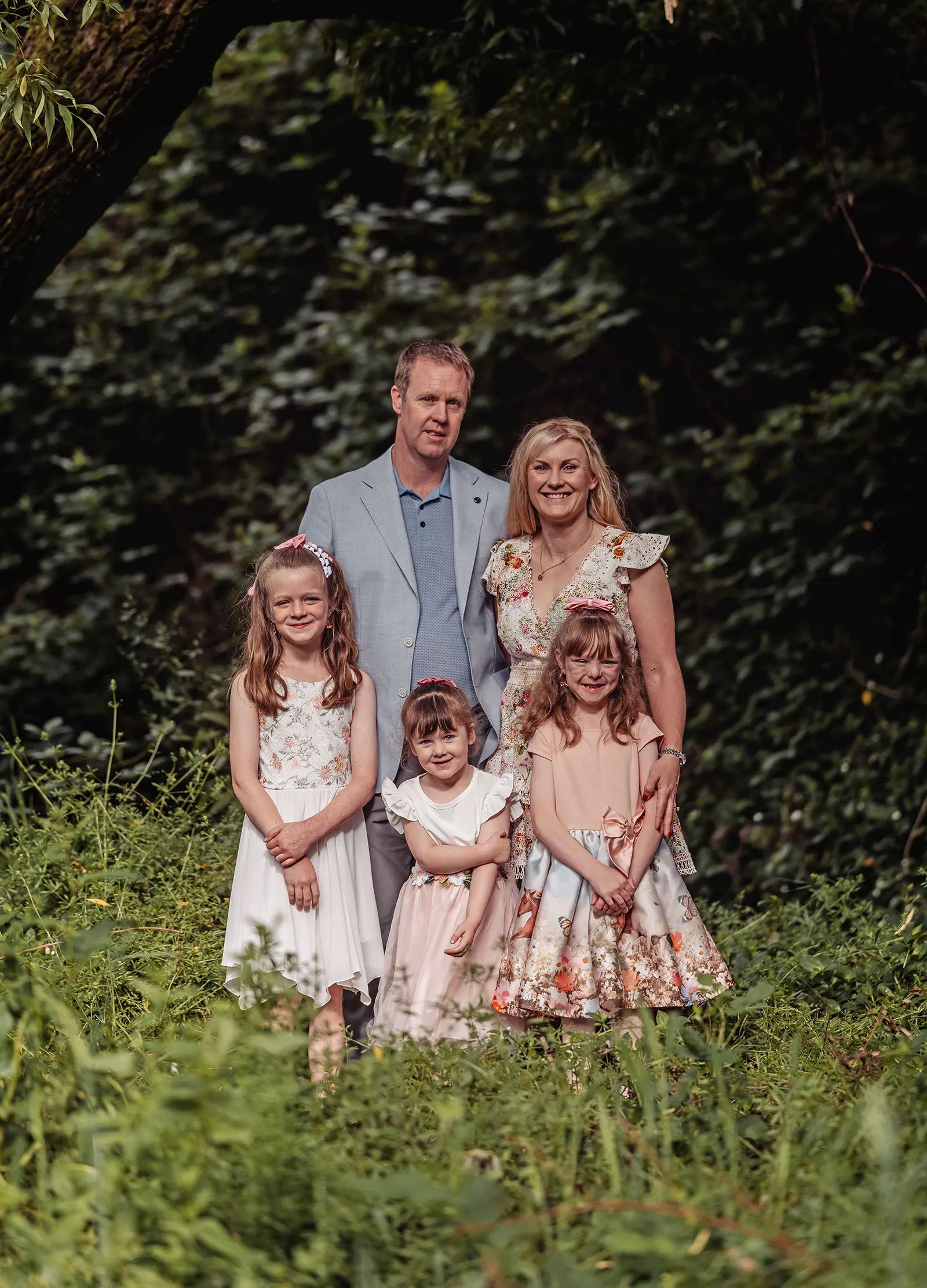 ironbank family photography 111 Family portrait in lush garden setting with joyful expressions and elegant, floral attire.