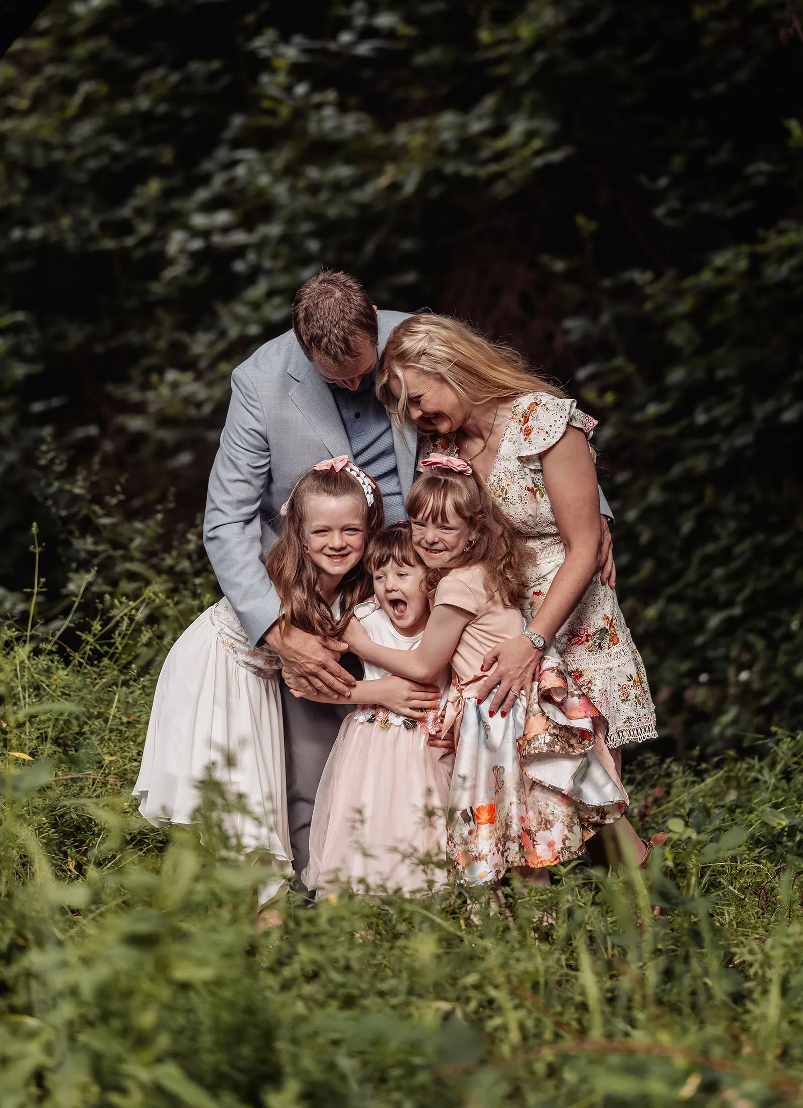 ironbank family photography 112 Family sharing a joyful embrace in a lush, green outdoor setting.