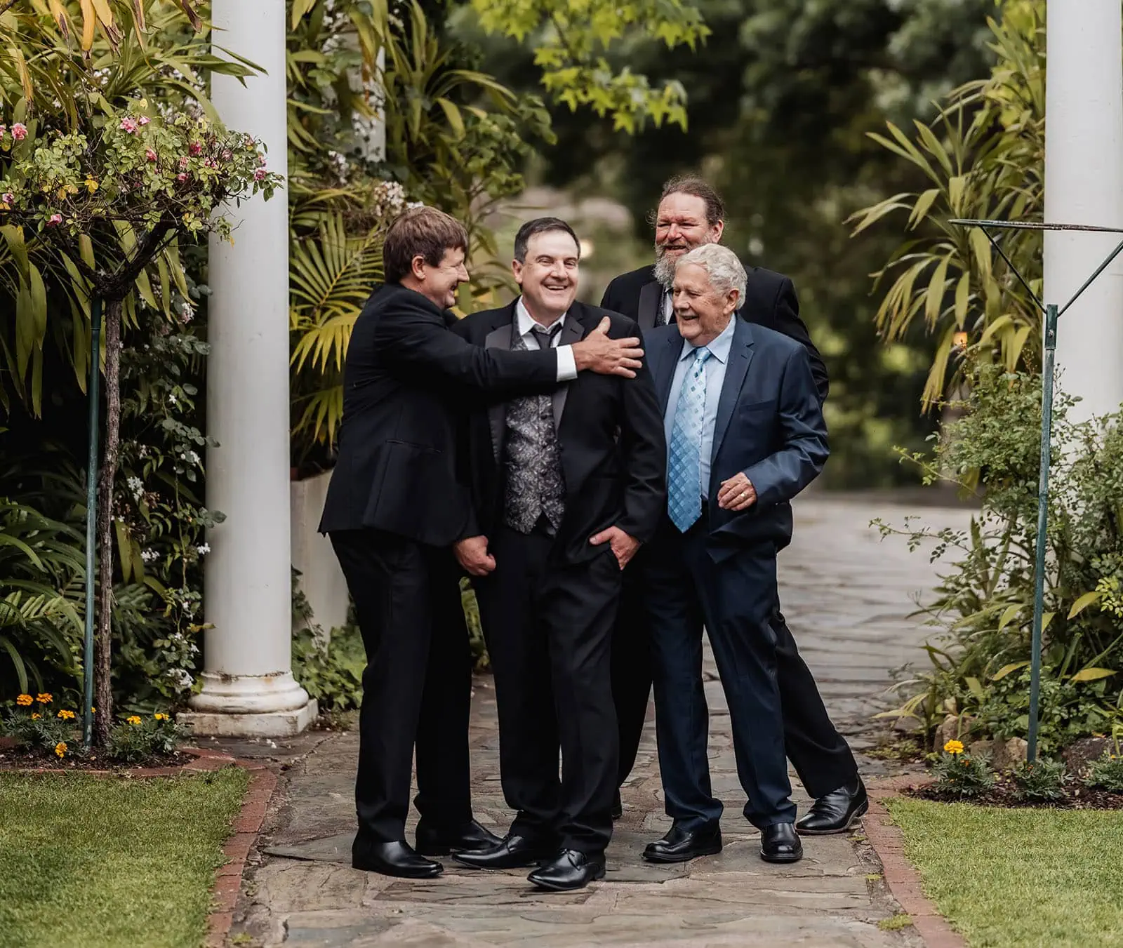 wedding at the manor in basket range - maryam & jason 118 Friends laughing together in a garden, enjoying nature and companionship.