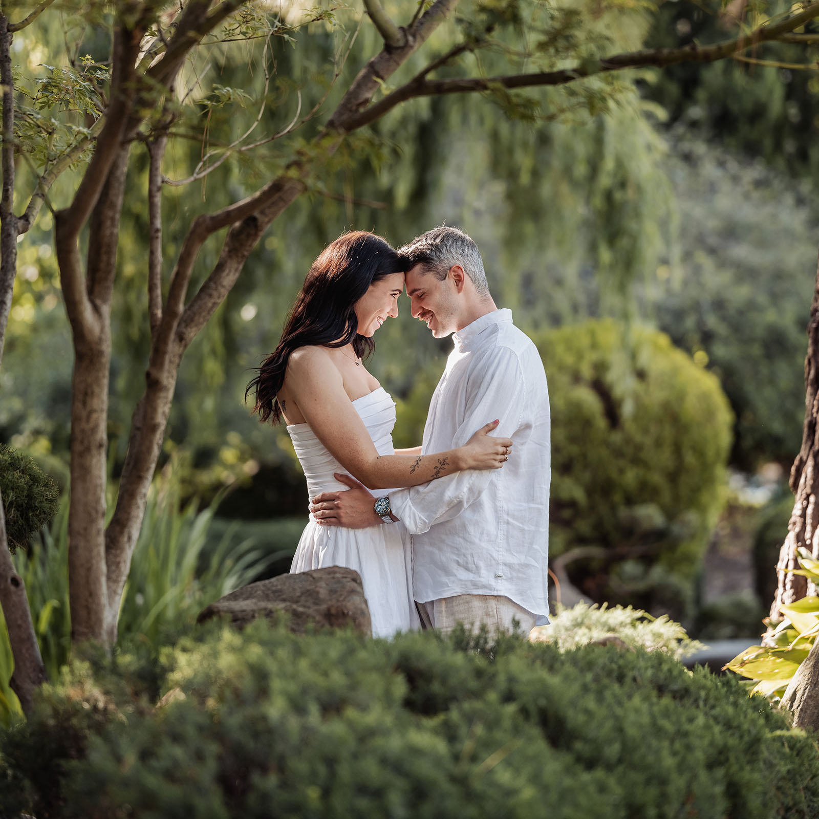 himeji gardens couples shoot - tom & tess 93 Romantic couple embracing in a lush garden.