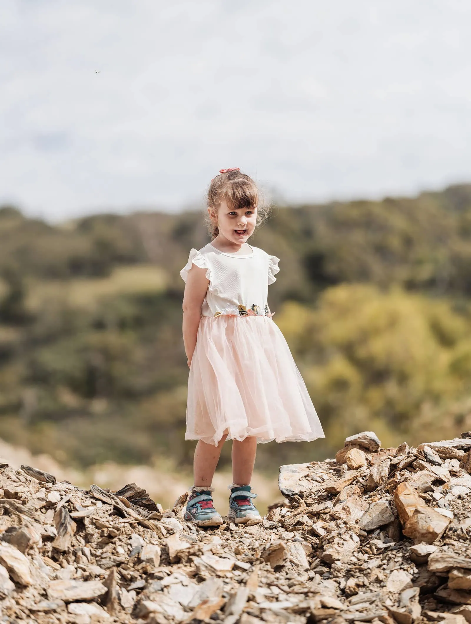 ironbank family photography 132 Young girl exploring rocky terrain in a floral dress and sandals.