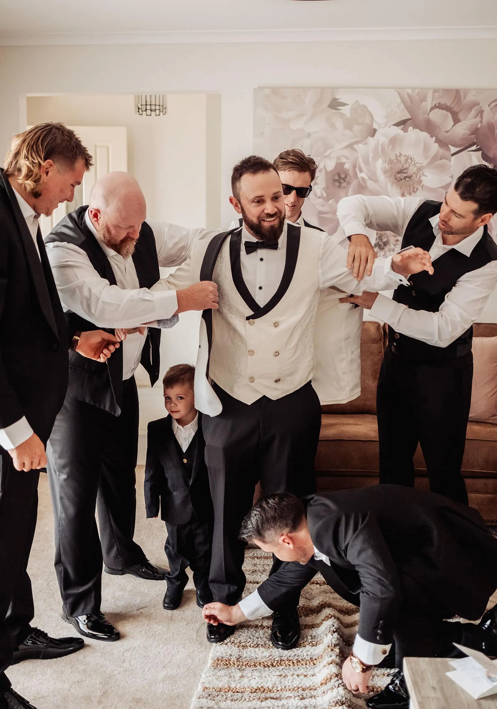 silvestris of clarendon wedding - sam & wayne 185 Groom getting ready for wedding, adjusting suit and tie in elegant setting.
