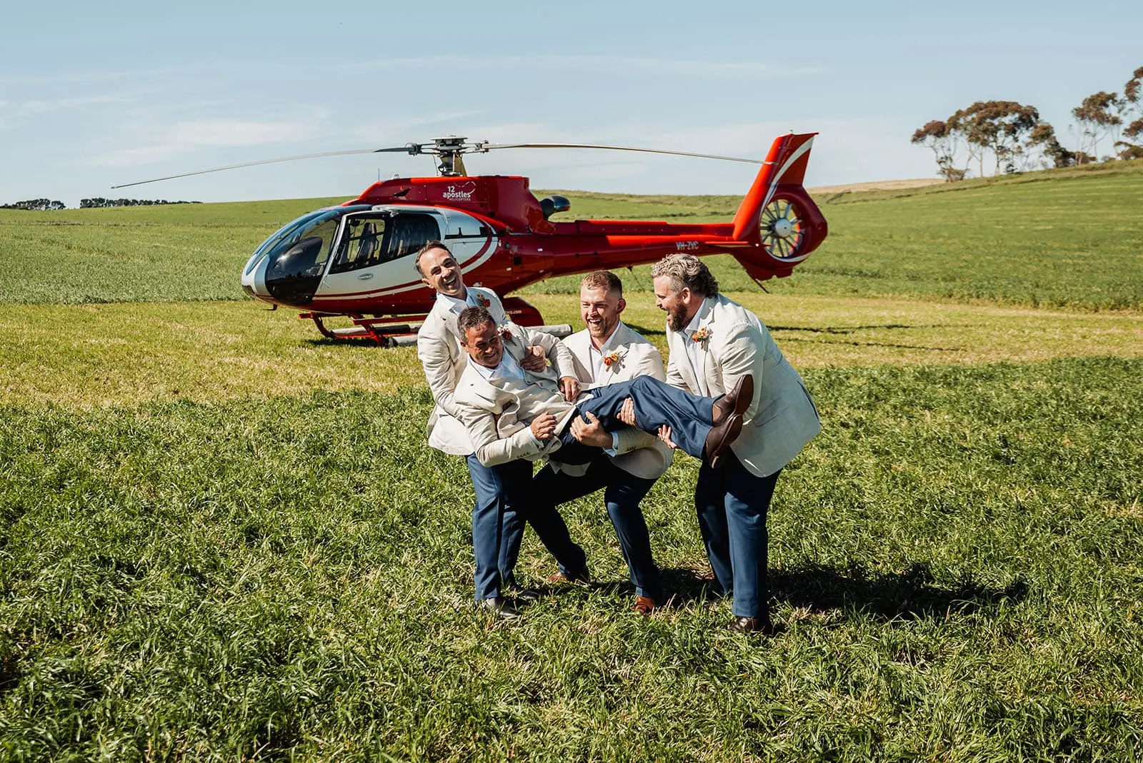country victoria wedding in corrunnun – rachelle & anthony 333 Helicopter landing on field during celebration event with spectators watching.