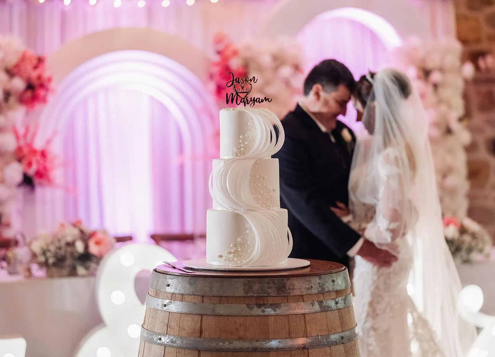 wedding at the manor in basket range - maryam & jason 150 Elegant wedding cake setup in a romantic, intimate setting with floral decorations.