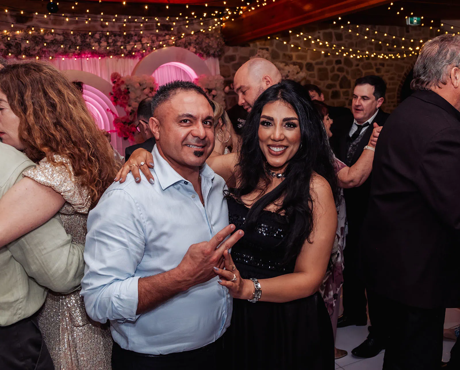 wedding at the manor in basket range - maryam & jason 172 People celebrating joyfully, with colorful balloons and confetti, expressing happiness.