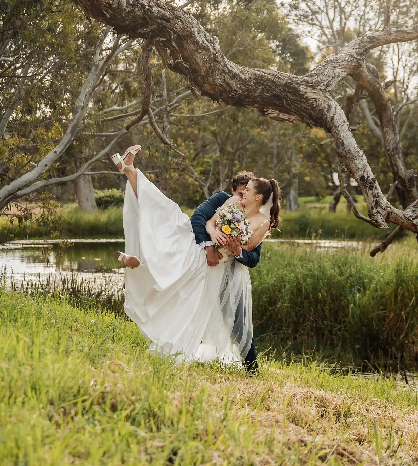 fleurieu cherries wedding - kimberley & richard 71 Happy couple relaxing by a serene pond in nature.