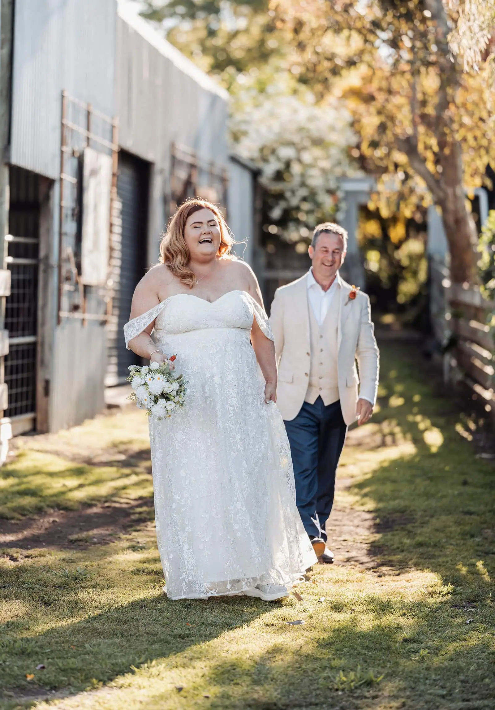 country victoria wedding in corrunnun – rachelle & anthony 352 Joyful couple walking a wedding path, celebrating love and happiness.