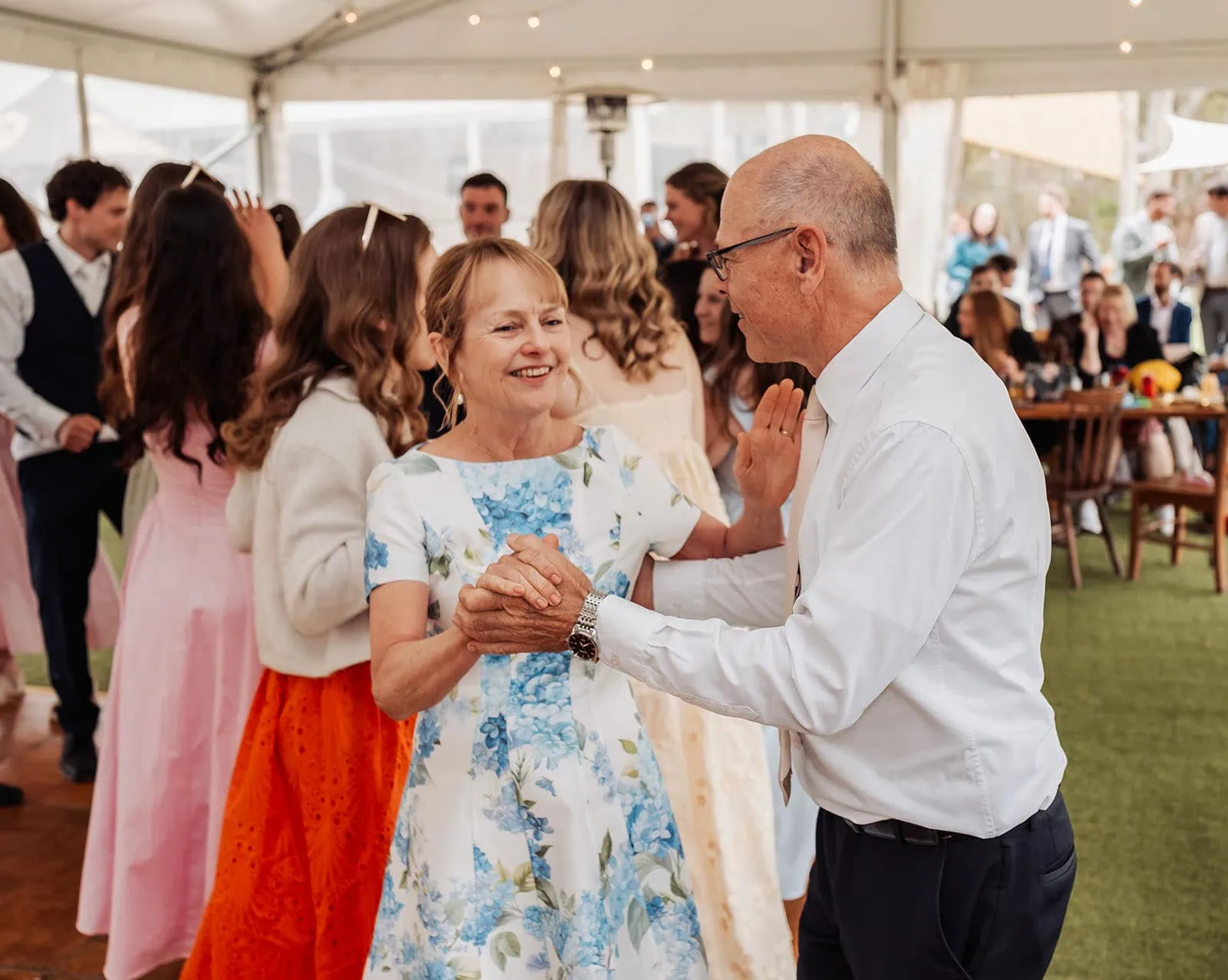 fleurieu cherries wedding - kimberley & richard 61 Joyful camping celebration with people enjoying a festive atmosphere under a large colorful tent.
