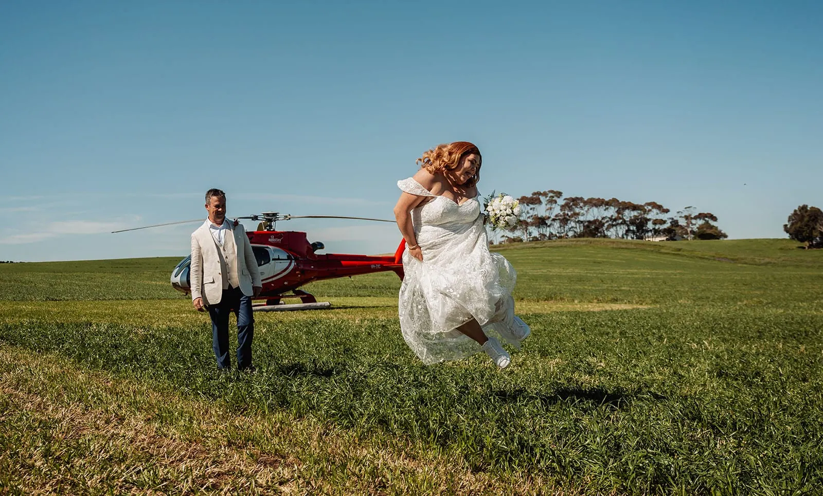 country victoria wedding in corrunnun – rachelle & anthony 334 Bride and groom joyfully leap, celebrating a vibrant wedding moment.