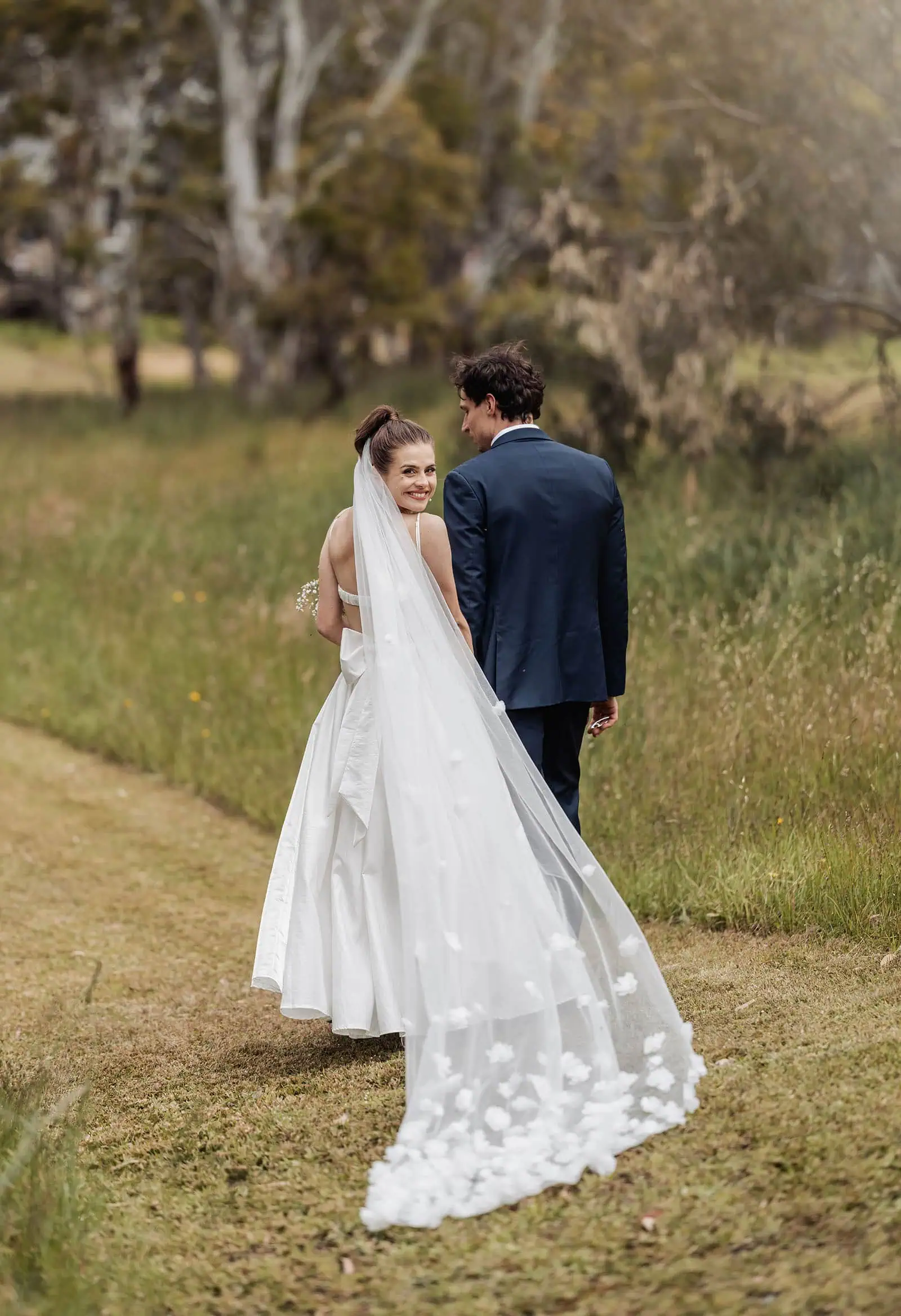 fleurieu cherries wedding - kimberley & richard 29 Newlywed couple strolling hand in hand on a sunny day.