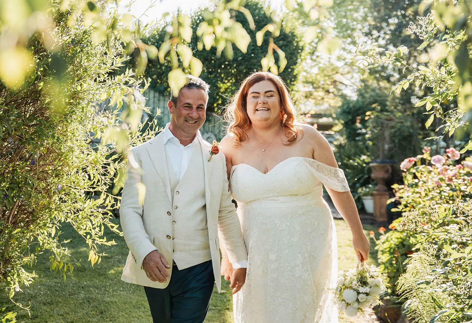 country victoria wedding in corrunnun – rachelle & anthony 357 Newlyweds stroll through lush garden, embracing natures beauty.