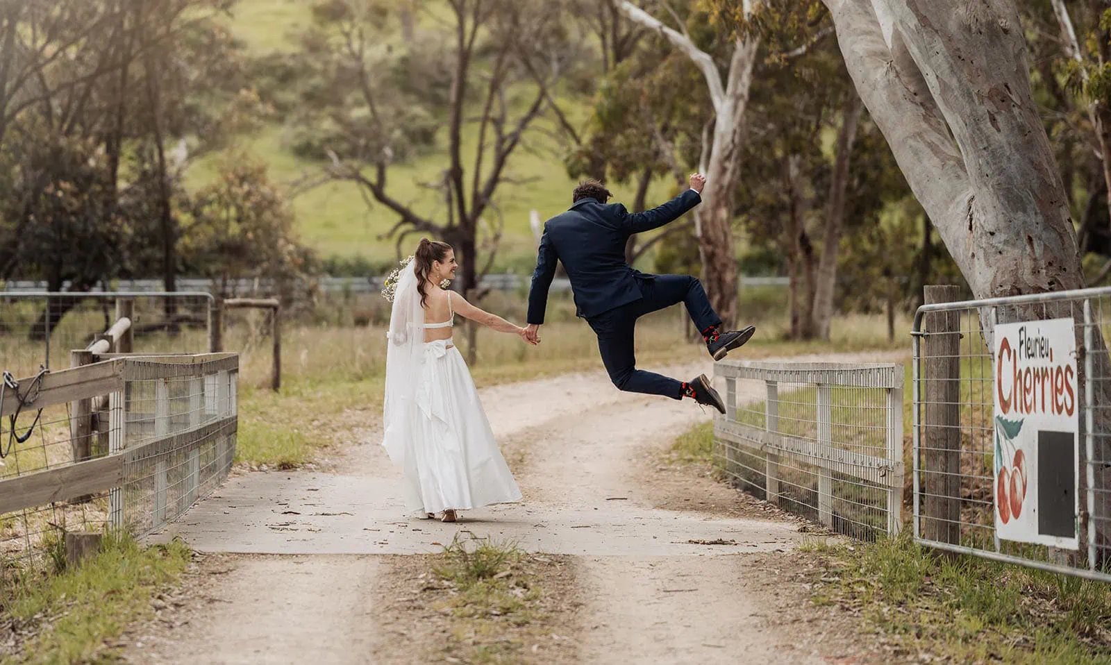 fleurieu cherries wedding - kimberley & richard 38 Newlywed couple walks down charming rustic path, surrounded by nature.