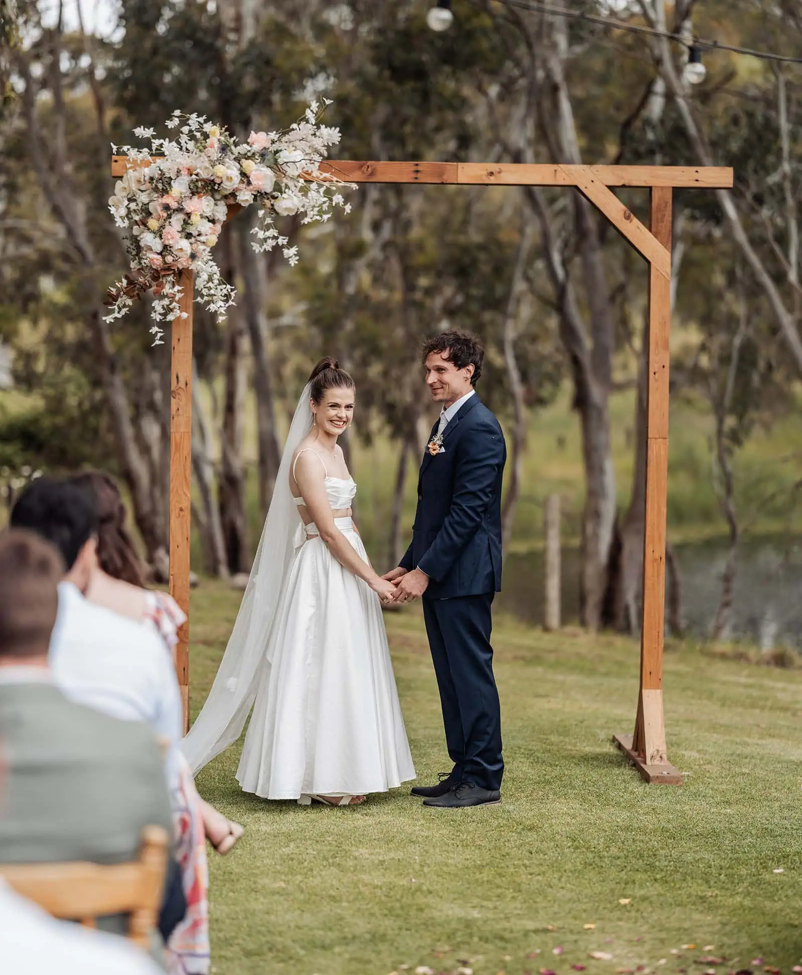 fleurieu cherries wedding - kimberley & richard 10 Elegant outdoor wedding ceremony with floral decorations and guests seated.