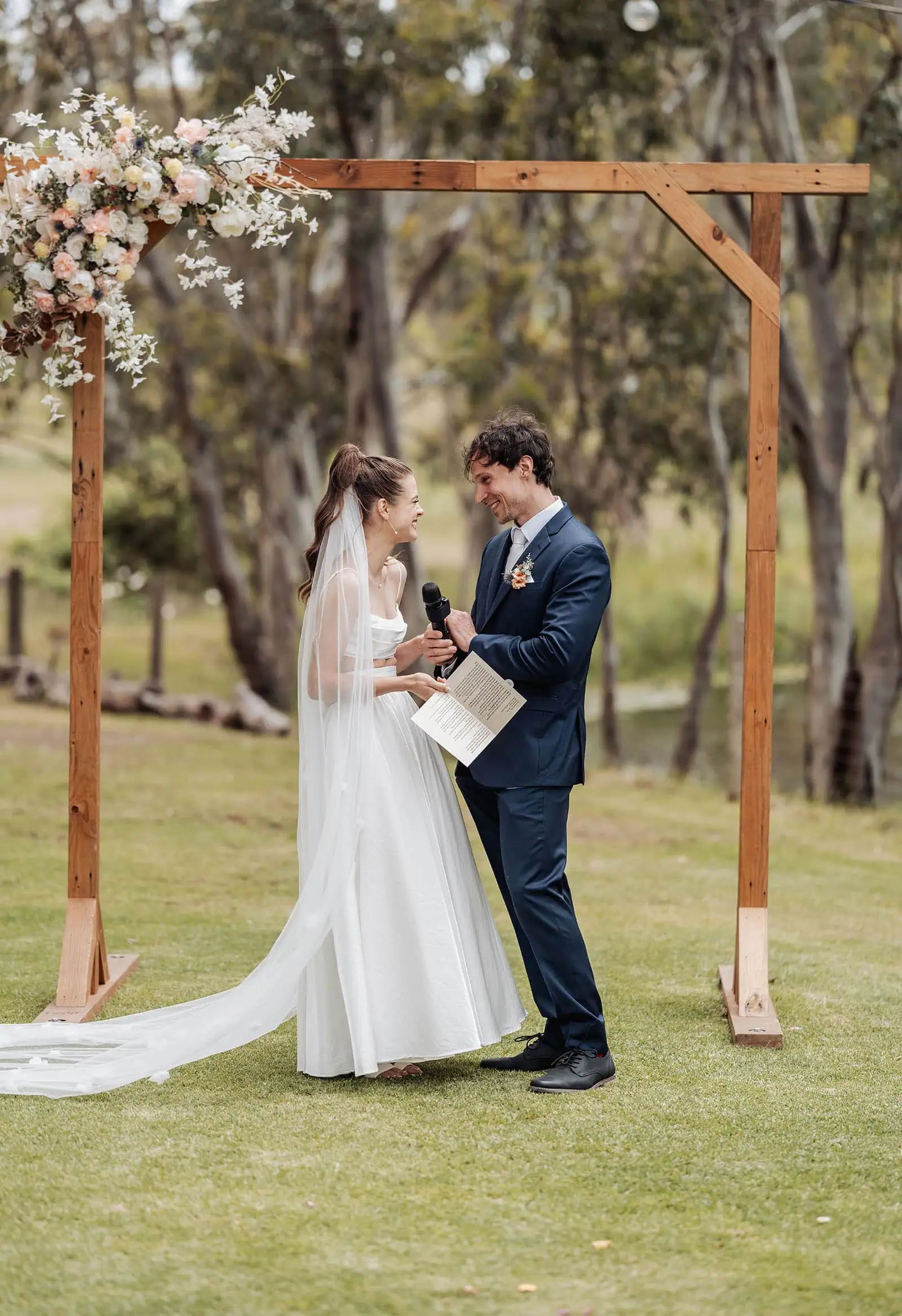 fleurieu cherries wedding - kimberley & richard 18 Outdoor wedding ceremony with elegant floral decorations and guests seated under sunny skies.