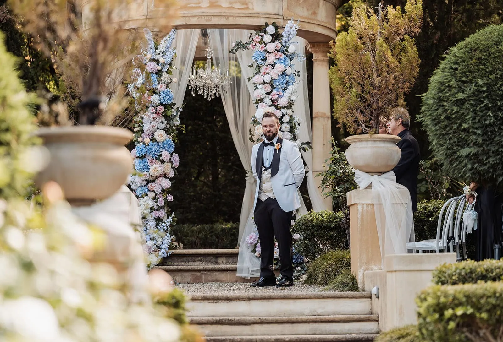 silvestris of clarendon wedding - sam & wayne 211 Elegant outdoor wedding ceremony with floral arch and scenic views.