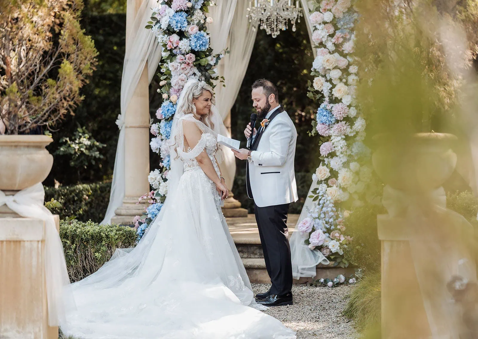 silvestris of clarendon wedding - sam & wayne 218 Elegant outdoor wedding ceremony with beautiful floral arrangements and guests under sunny skies.