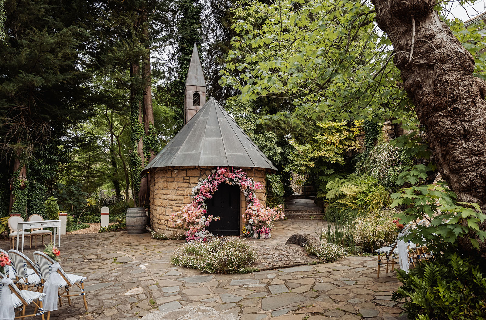 wedding at the manor in basket range - maryam & jason 131 Elegant outdoor wedding ceremony setup with white chairs and floral decorations.