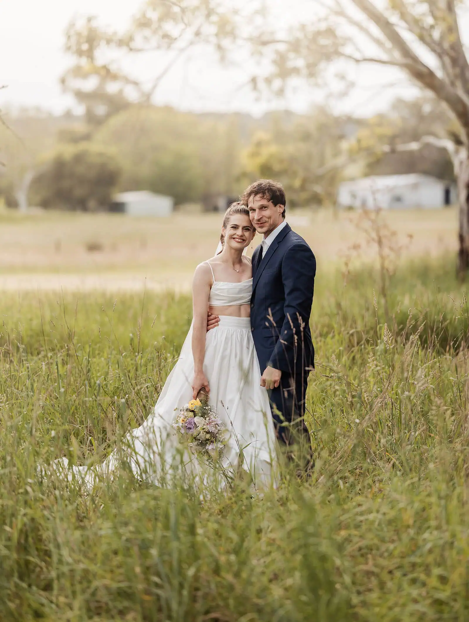 fleurieu cherries wedding - kimberley & richard 74 Romantic couple embracing in serene countryside, scenic nature background.