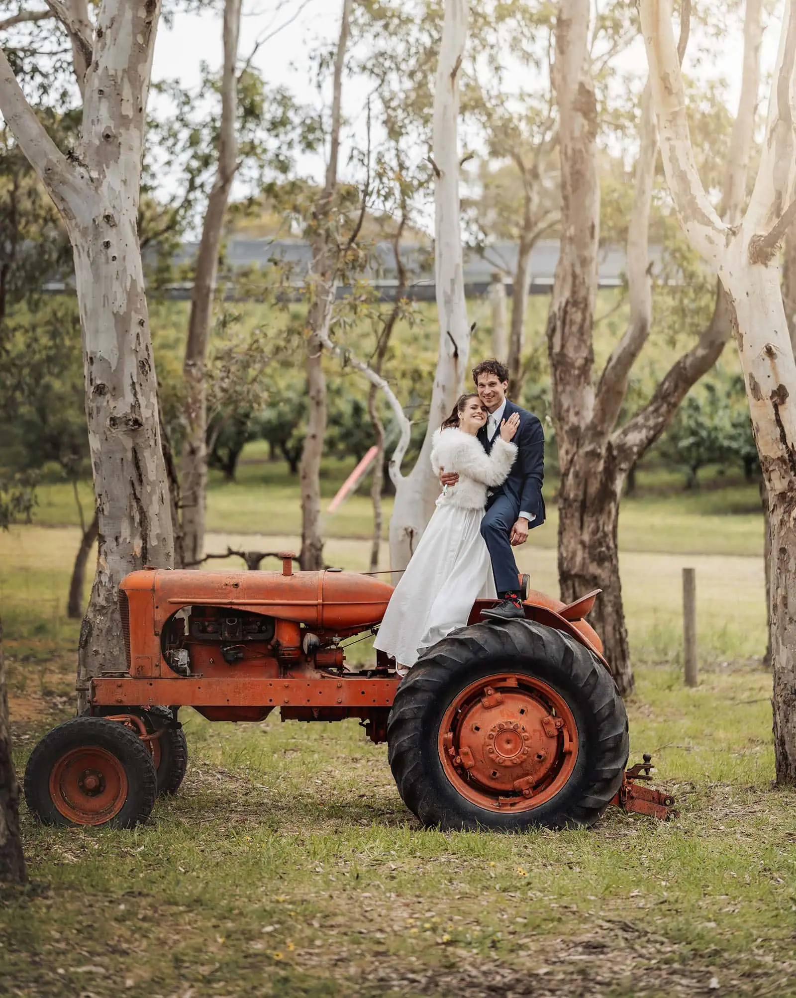 fleurieu cherries wedding - kimberley & richard 48 Couple embracing on a tractor in a romantic, rural setting.