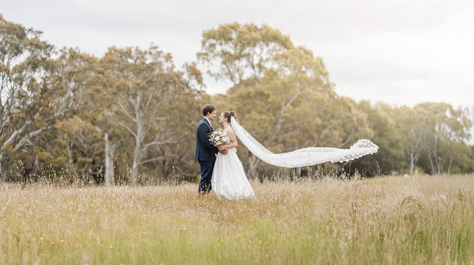 fleurieu cherries wedding - kimberley & richard 36 Couple embracing in sunlit field, romantic scenery, love, outdoors.