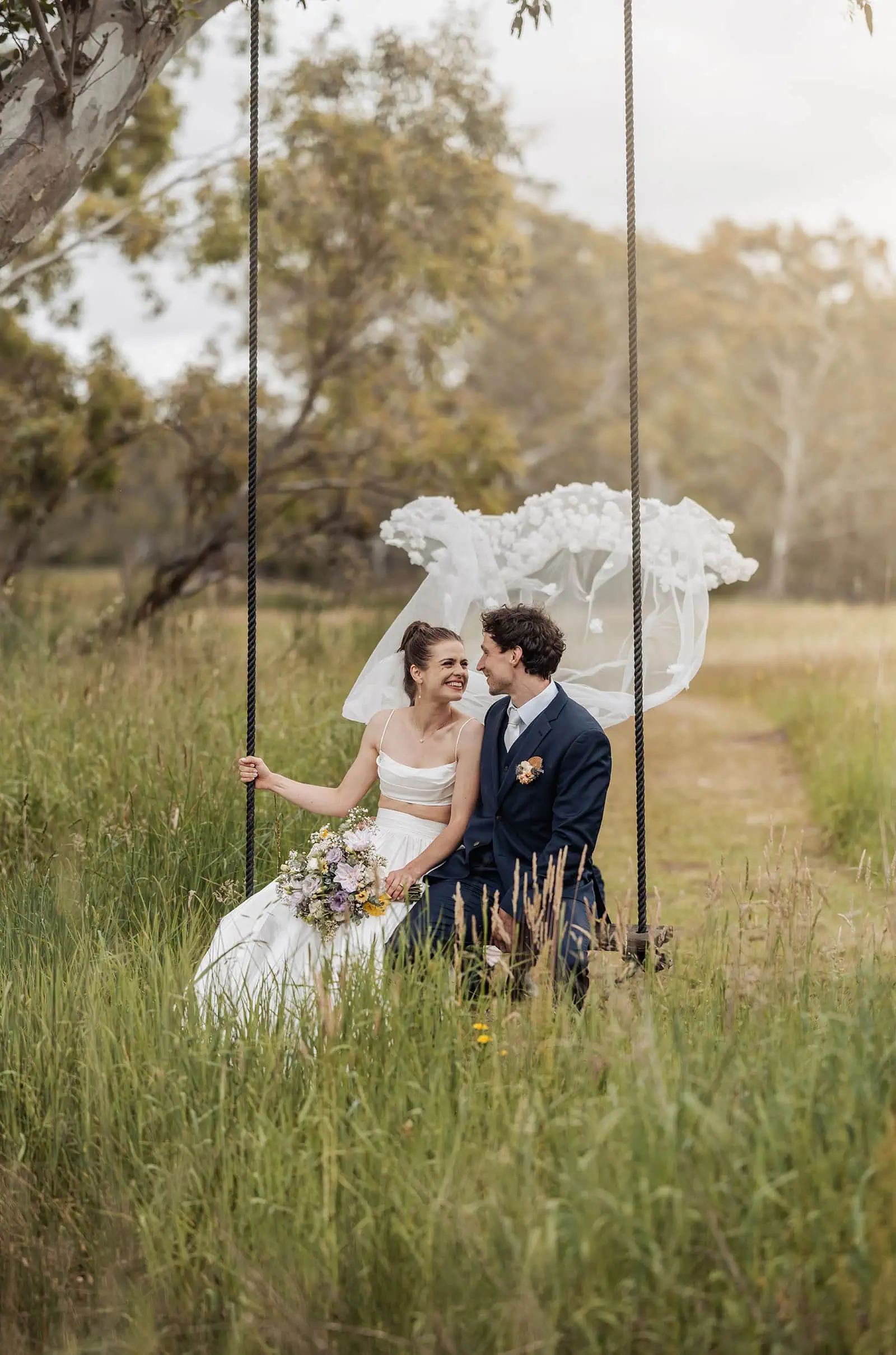 fleurieu cherries wedding - kimberley & richard 24 Romantic wedding couple on a swing under a canopy of trees.