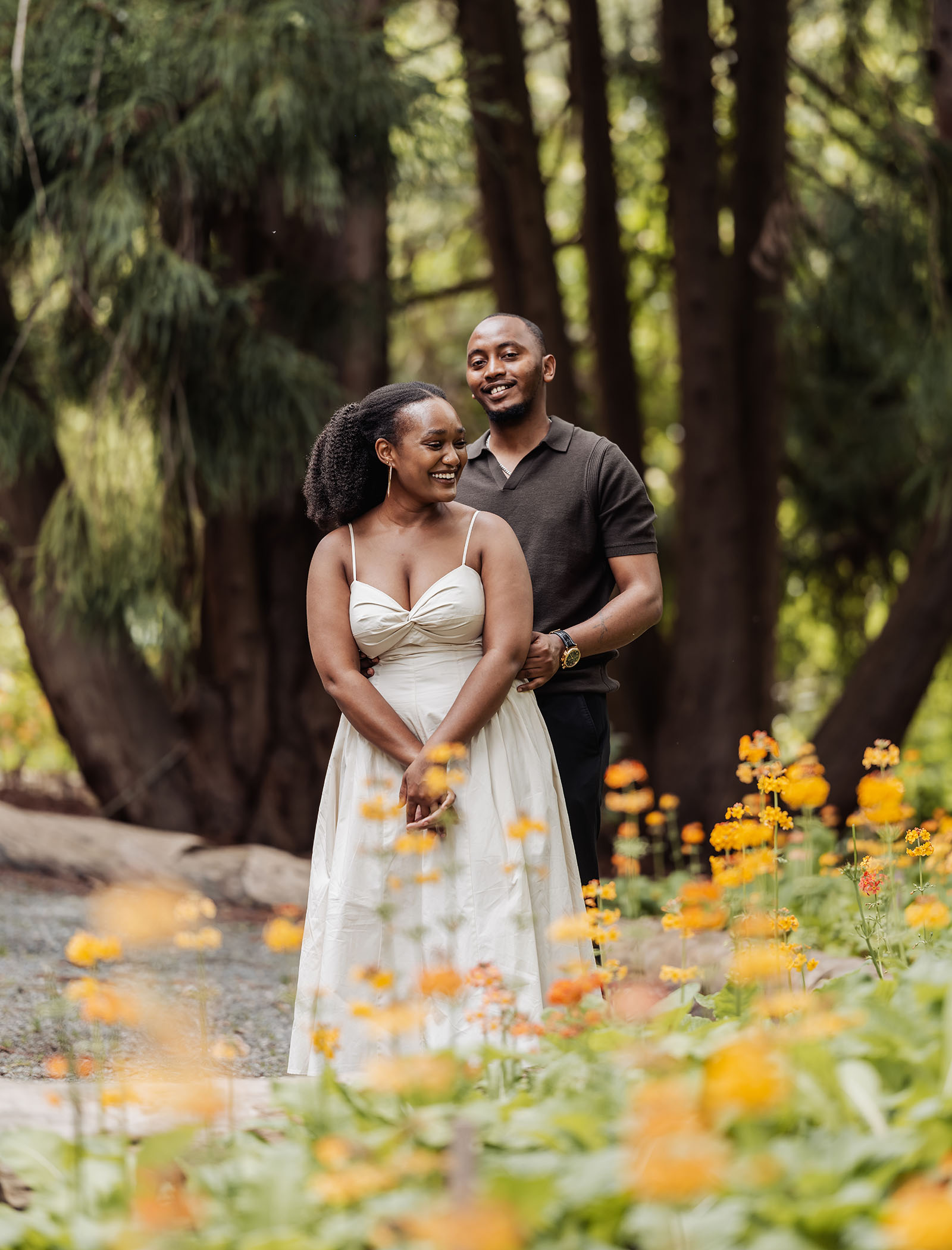 mt lofty botanic gardens couples shoot – ruth & emanuel 16 Couple sitting peacefully in blooming garden, surrounded by vibrant flowers.