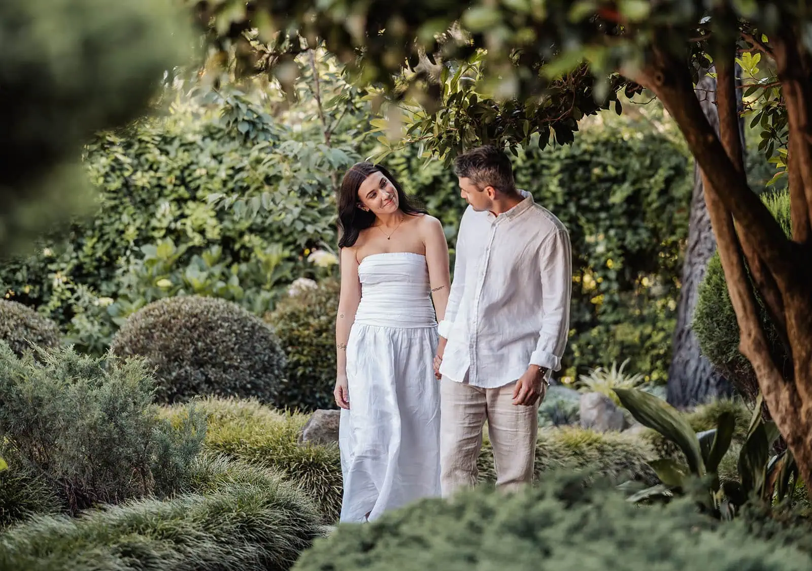 himeji gardens couples shoot - tom & tess 107 Romantic couple enjoying a peaceful stroll in a lush green garden.