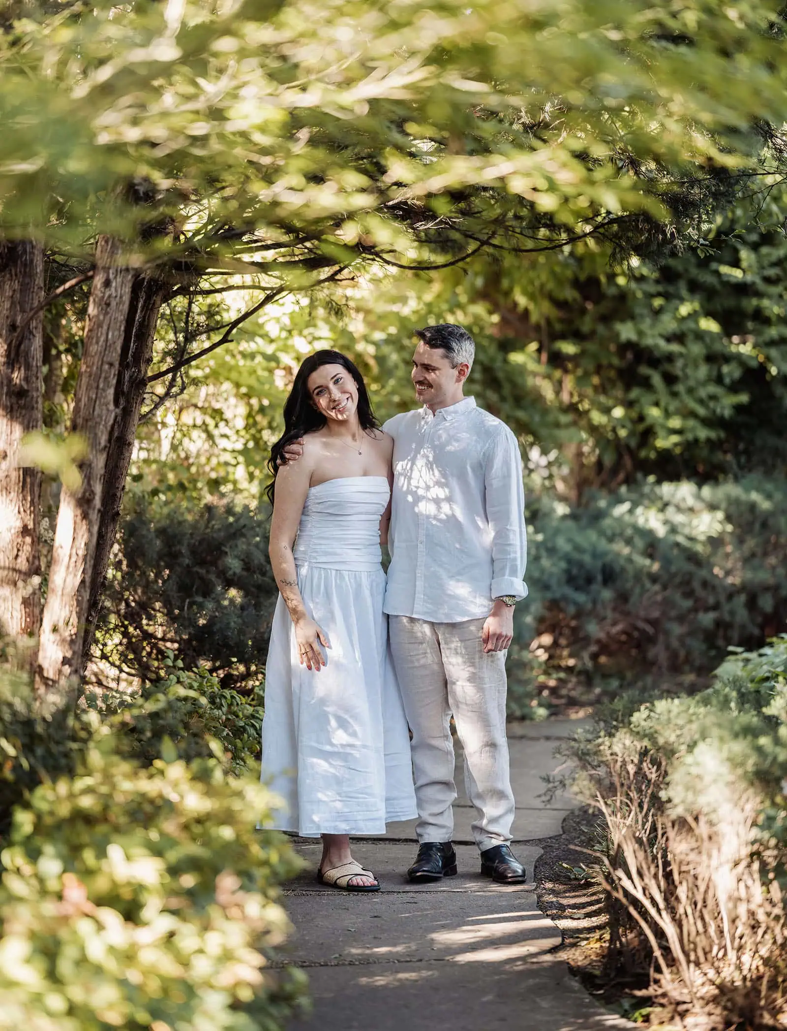 himeji gardens couples shoot - tom & tess 90 Couple enjoying a tranquil garden setting with lush greenery and blooming flowers.