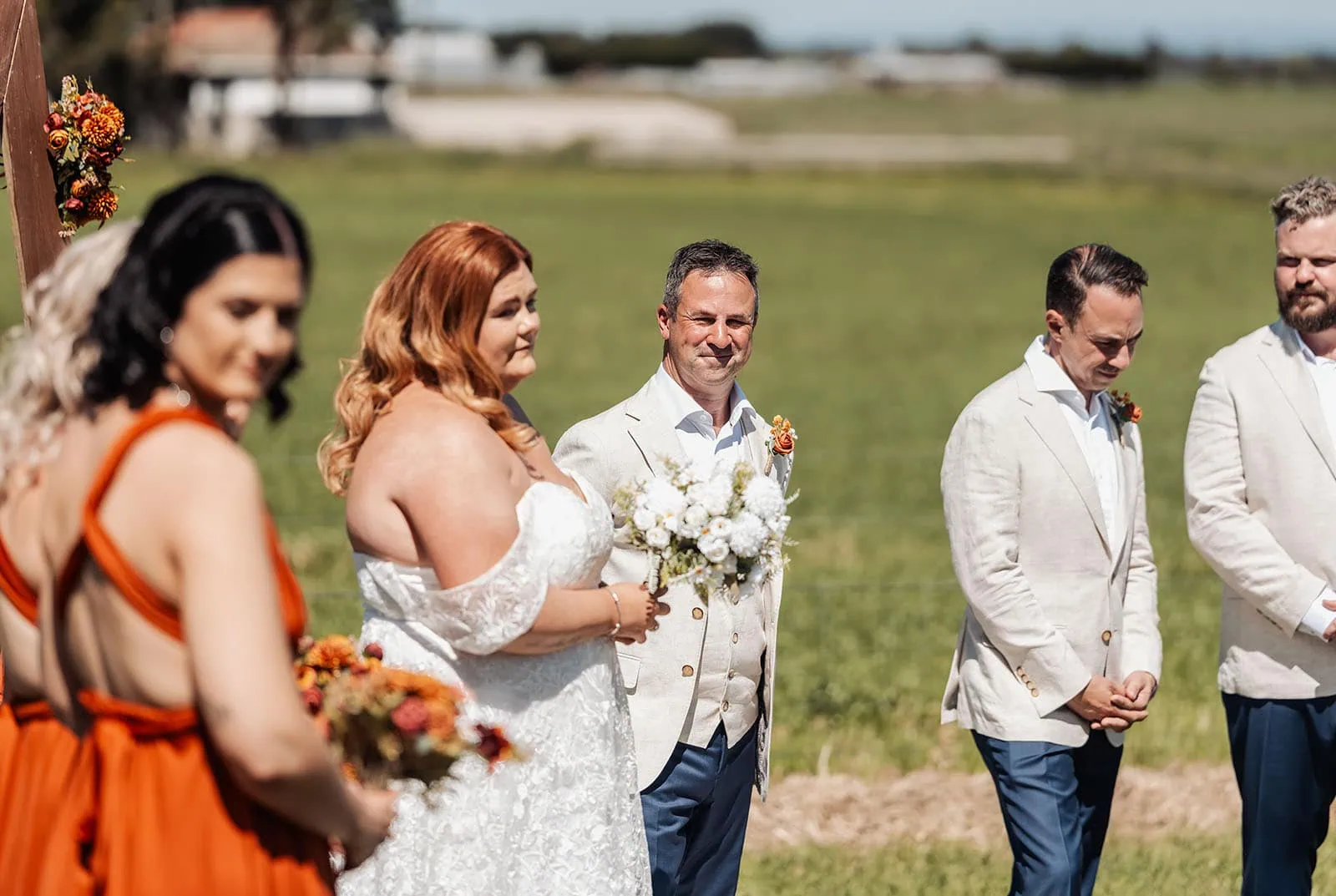 country victoria wedding in corrunnun – rachelle & anthony 318 Elegant outdoor wedding ceremony under sunny skies with floral arrangements.