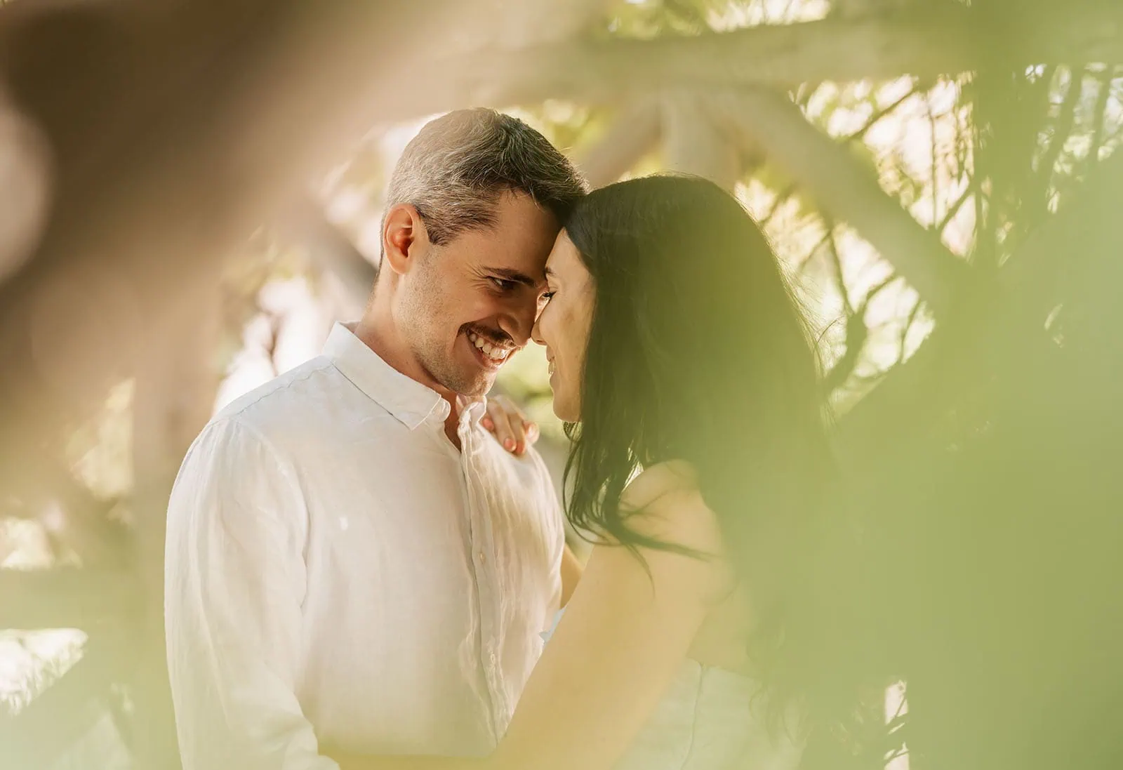 himeji gardens couples shoot - tom & tess 109 Couple embracing in a serene outdoor setting, lush greenery in the background.