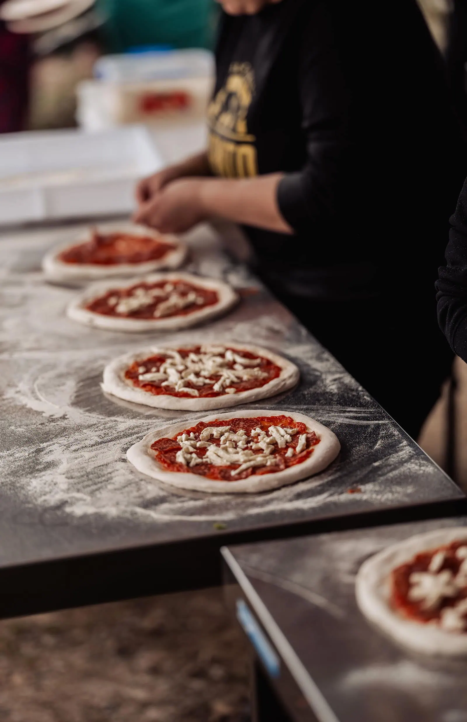 fleurieu cherries wedding - kimberley & richard 46 Raw pizzas with toppings on kitchen counter.