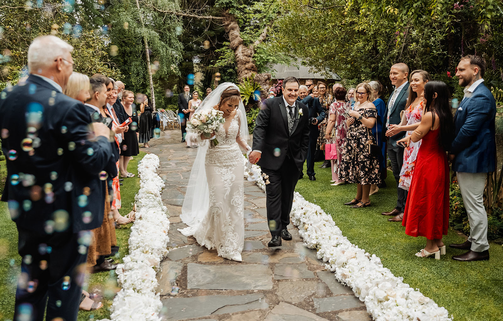 wedding at the manor in basket range - maryam & jason 140 Elegant garden wedding ceremony with floral decorations and guests.