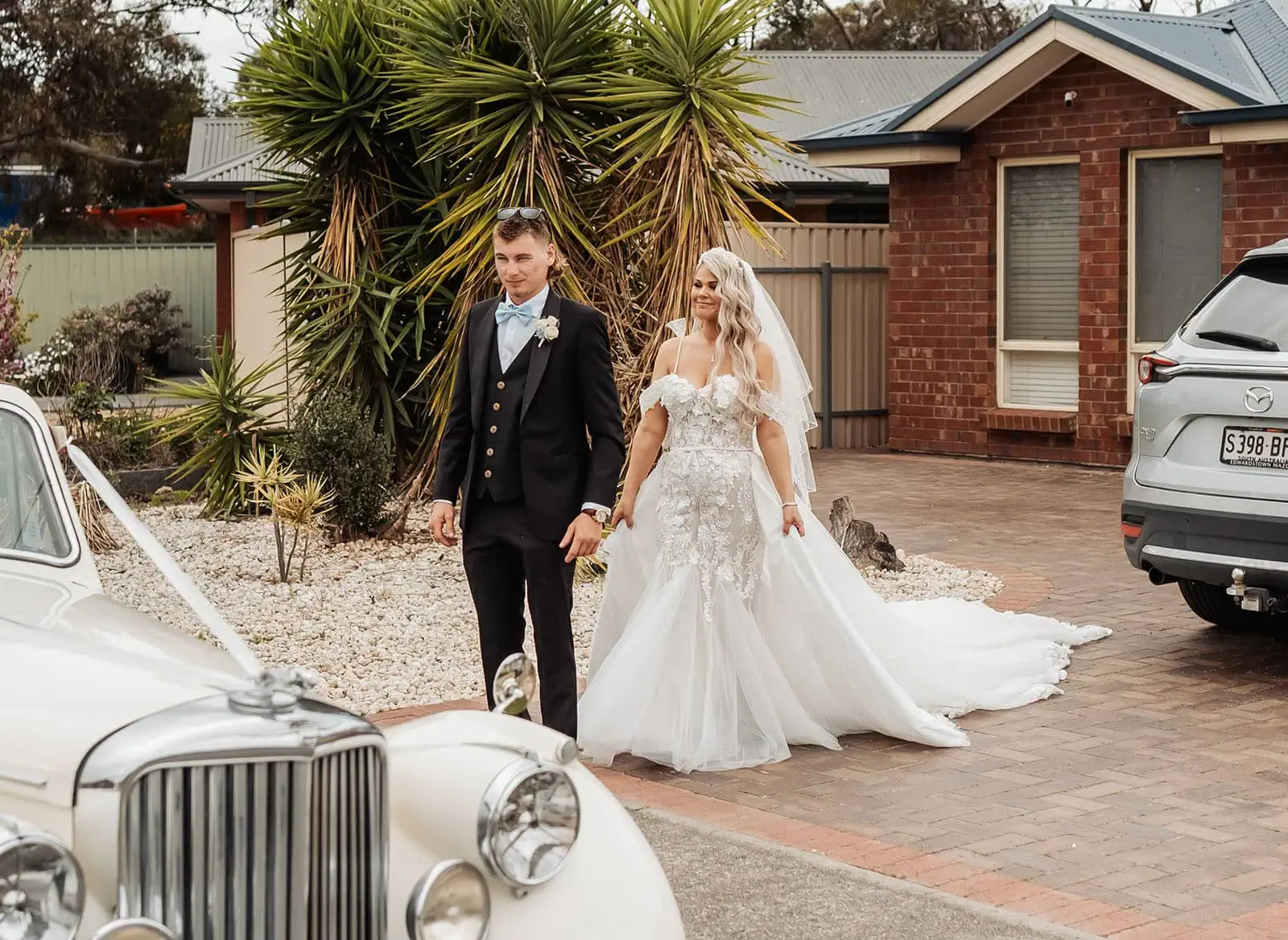 silvestris of clarendon wedding - sam & wayne 204 Bride and groom with elegant luxury cars at glamorous wedding celebration.
