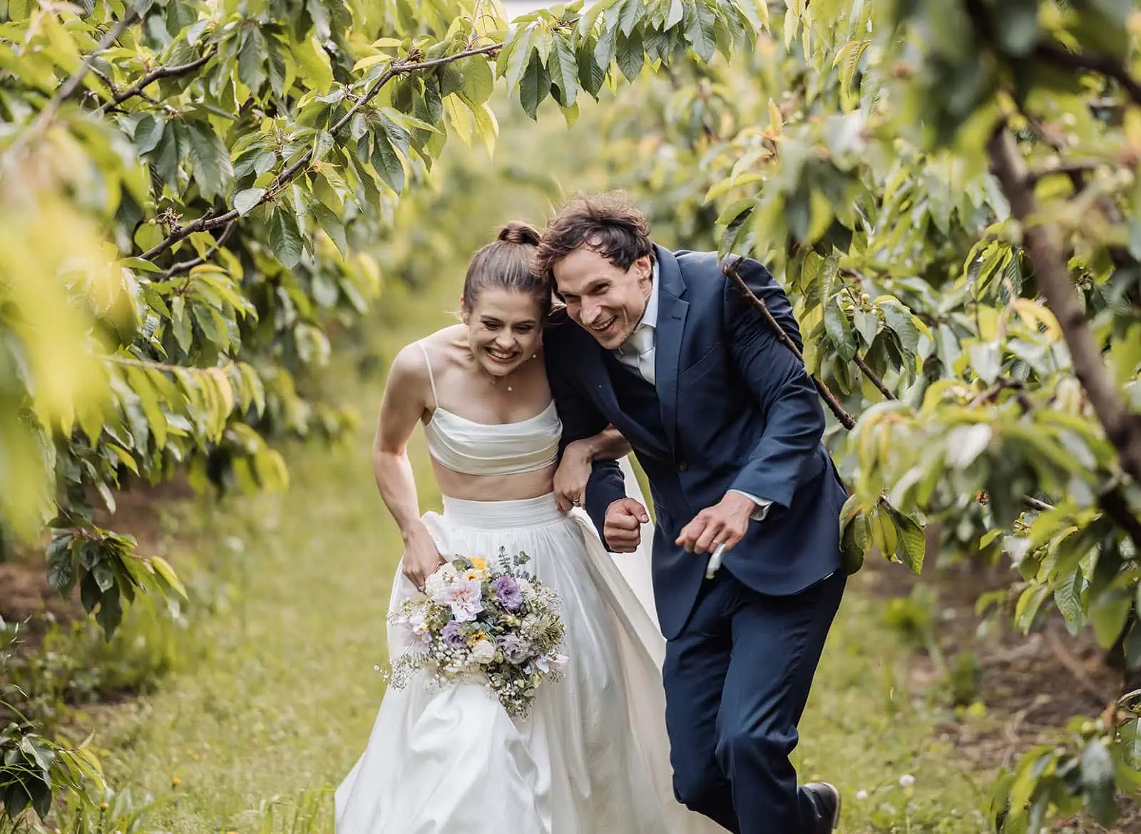fleurieu cherries wedding - kimberley & richard 83 Bride and groom celebrating joyfully in blooming orchard.