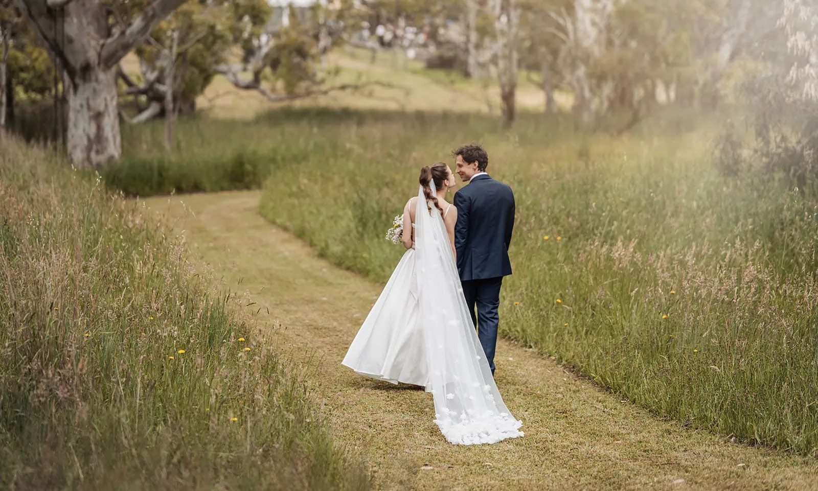 fleurieu cherries wedding - kimberley & richard 28 Bride and groom walking down a scenic path at sunset.