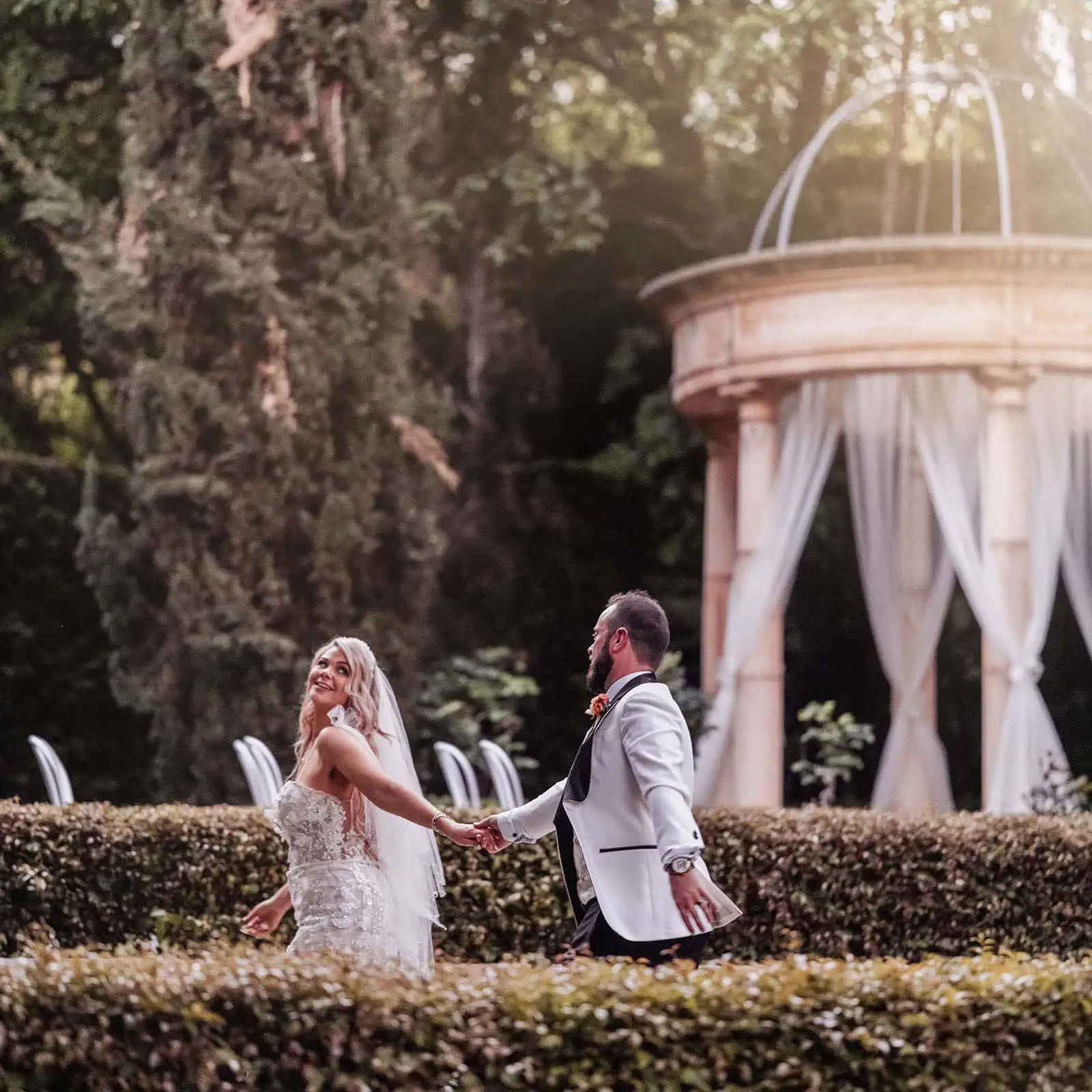 silvestris of clarendon wedding - sam & wayne 245 Bride and groom embrace in a vibrant garden wedding ceremony.