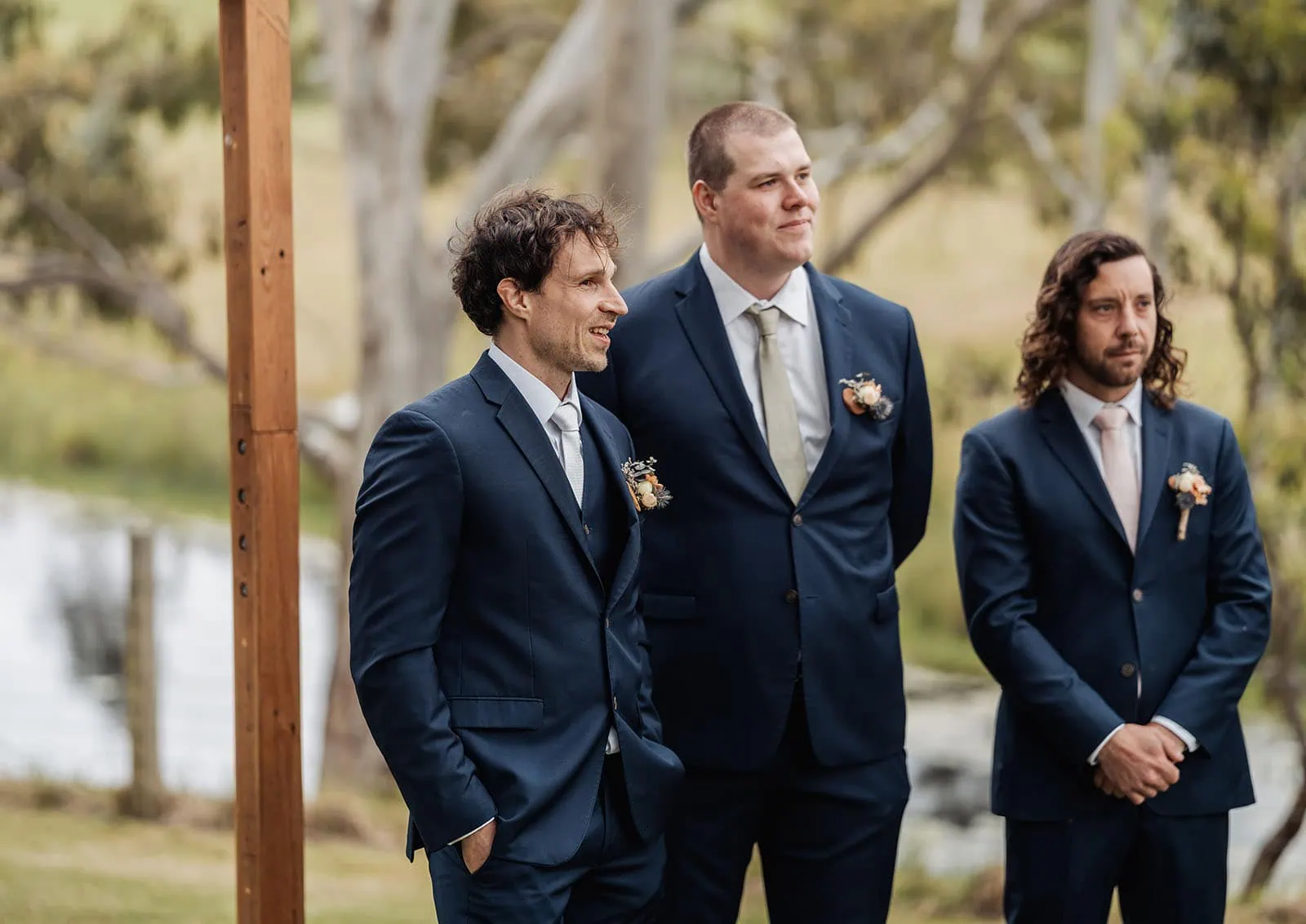 fleurieu cherries wedding - kimberley & richard 2 Groomsmen in suits pose outdoors during wedding ceremony.