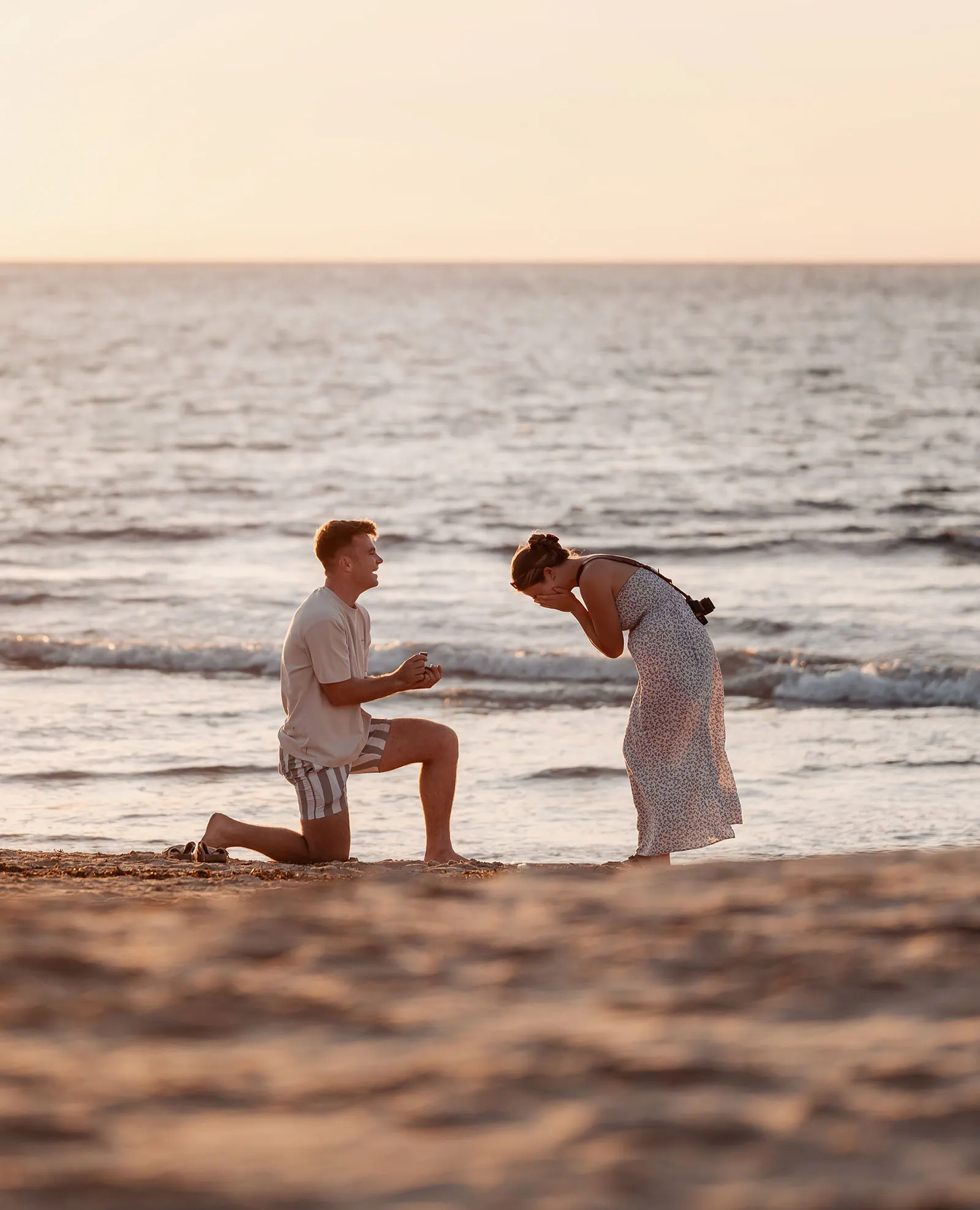 christies beach proposal – hollie & william 33 Sunset beach proposal: man kneels with ring, woman reacts with joy. Romantic moment captured.