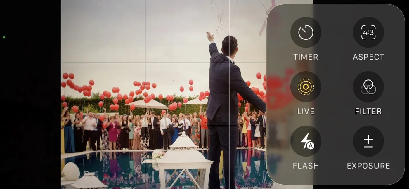 how to shoot great wedding photos as a guest on your iphone? 21 Outdoor celebration with red balloons, diverse crowd, and decorative structure reflecting in water.