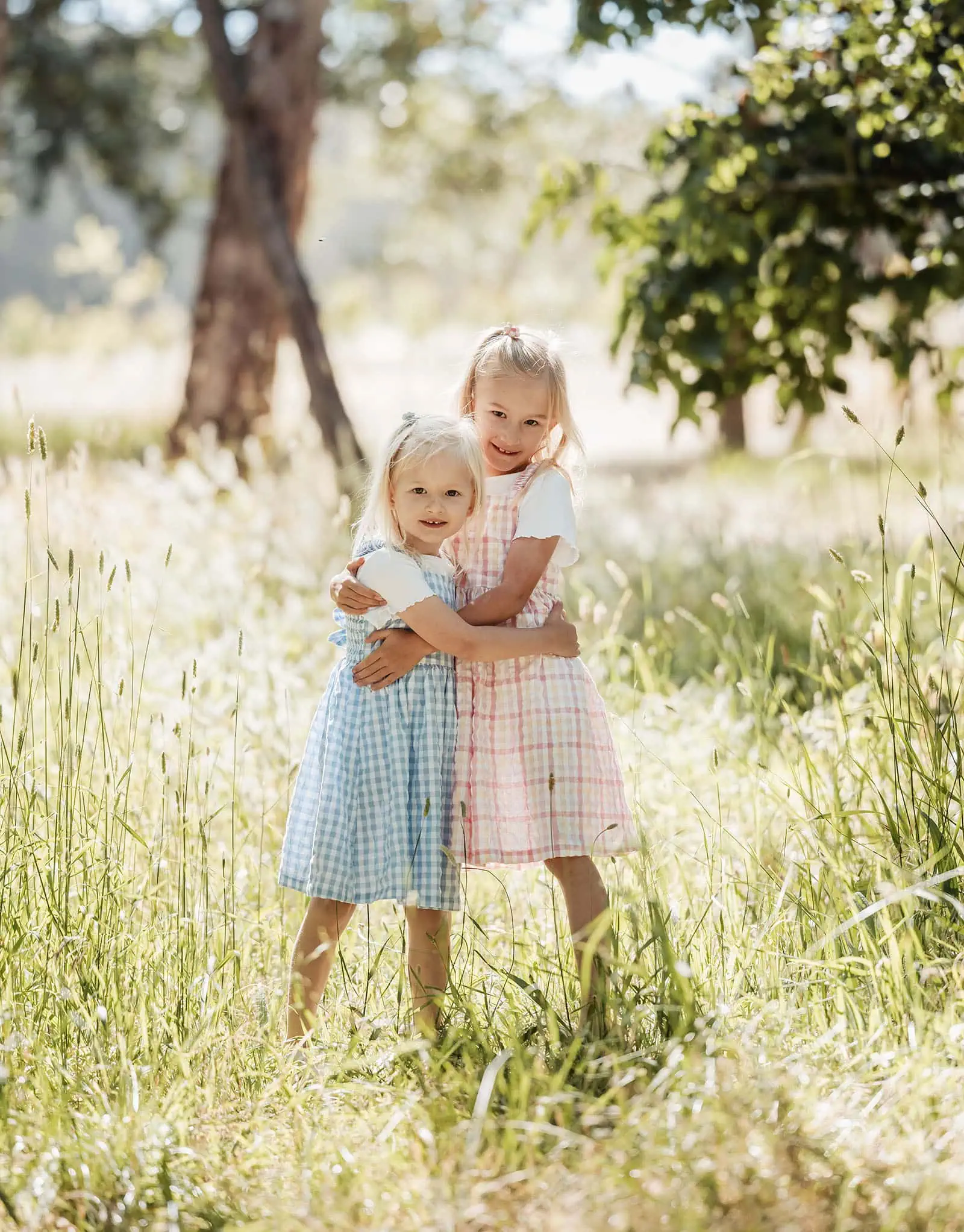 blackwood forest family photography 63 Two young girls in checkered dresses enjoying natures beauty at sunset.