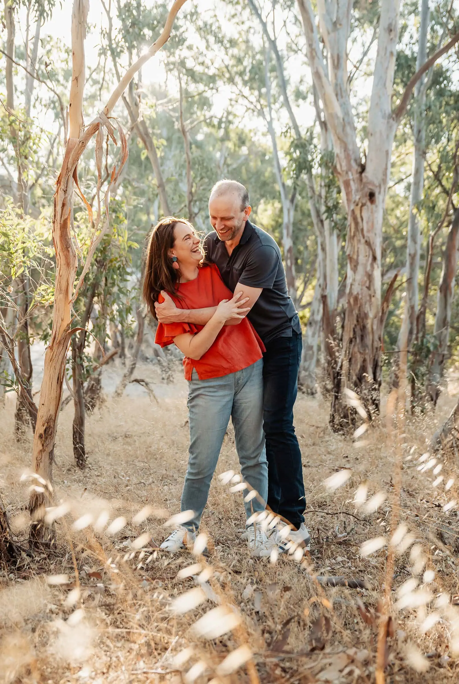 beautiful anstey hill family photoshoot 20 Couple laughing together in a serene woodland setting.